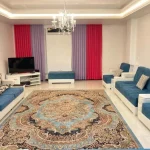 اتاق پذیرایی فرش شده به همراه مبلمان و تلوزیون رو میزی واحد آپارتمان در نشتارود 48578465476
