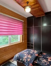 تختخواب با روتختی سرمه ای و پرده صورتی رنگ آپارتمان در سلمان شهر