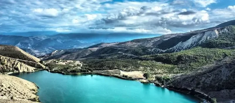 دریاچه آبی احاطه شده در کوهستان در زیر آسمان آبی ابری دریاچه ولشت عباس آباد 15641689498741